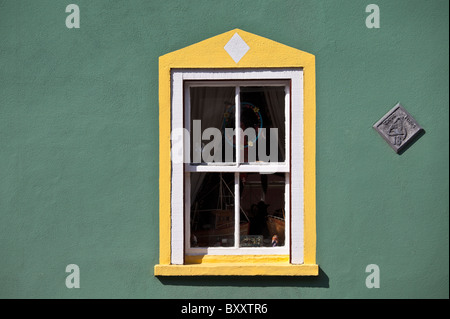 Aquamarine colour wall and yellow window border in Kinsale, County Cork, Ireland Stock Photo