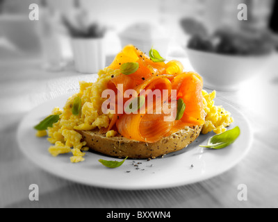 Smoked salmon and scrambled eggs on a bagel on a table setting. Stock Photo