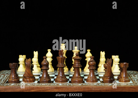 Closeup of chess pieces on chess board against black background Stock Photo