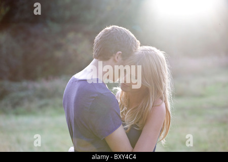 A romantic young couple embracing in the evening sun Stock Photo