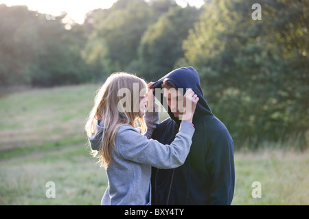 A young couple outdoors, wearing hooded sweatshirts Stock Photo