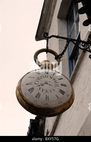 An antique dealers sign depicting a giant pocket watch at Woburn in Bedfordshire, UK. Stock Photo