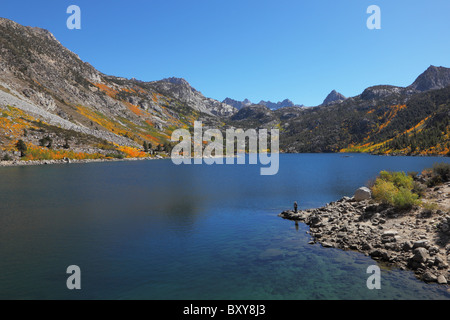Picturesque island on mountain lake. Fishing boats off the island. Stock Photo