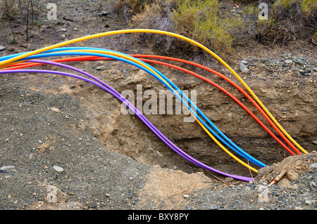 Colorful fiber optical cables are buried in a ditch. South Africa. Stock Photo