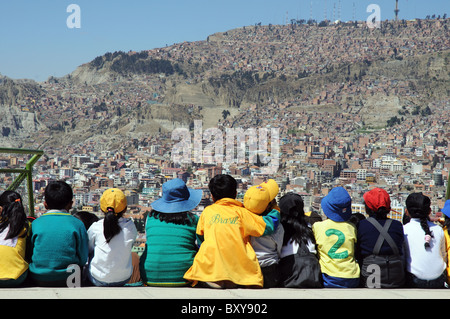 A row of school children looking out across La Paz in Bolivia Stock Photo