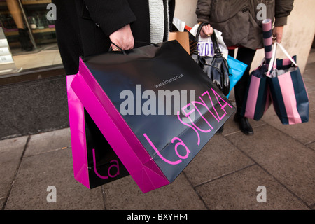 UK, England, Yorkshire, Leeds, City Centre, shoppers holding carrier bags full of Christmas shopping Stock Photo