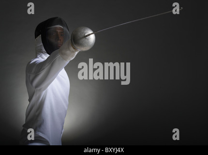 Studio portrait of fencer holding fencing foil Stock Photo