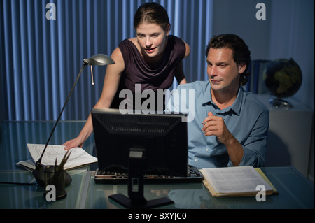 Man and woman working late in office Stock Photo