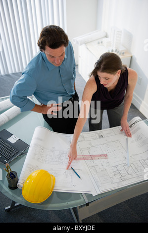 Architects with blueprints in office Stock Photo