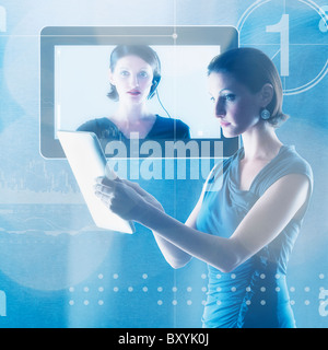 Young woman using tablet in front of monitor Stock Photo