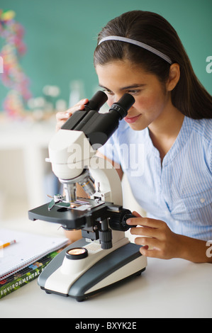 Schoolgirl using microscope in science class. Technologies, lessons and ...