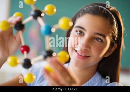 Schoolgirl looking at molecular model Stock Photo