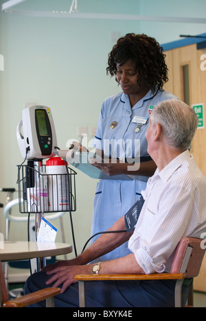 A young black nurse works on a hospital ward UK Stock Photo