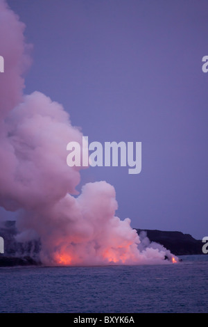 An erupting volcano in Hawaii Volcanoes National Park at dusk. Stock Photo