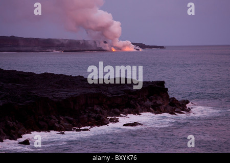 An erupting volcano in Hawaii Volcanoes National Park at dusk. Stock Photo