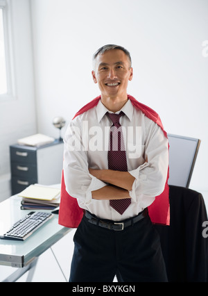 Portrait of smiling businessman wearing red cape Stock Photo