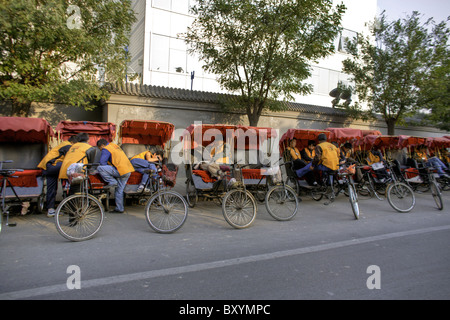 CHINA, BEIJING:  Pedicab drivers pass the time as they wait for customers in the Hutong neighborhood of Beijing Stock Photo