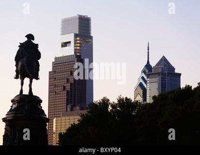 Silhouette of statue, skyscrapers in background Stock Photo