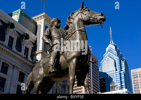 Statue depicting man on horse, skyscrapers in background Stock Photo