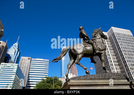 Statue depicting man on horse, skyscrapers in background Stock Photo