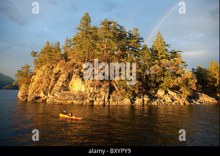 Hispanic woman kayaking on lake Stock Photo