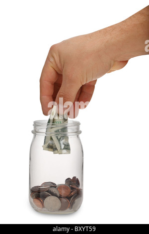 Hand putting money into jar on white background Stock Photo