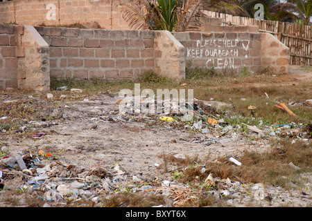 Trash litters a beach in Ghana in spite of the sign asking to keep the beach clean. Stock Photo