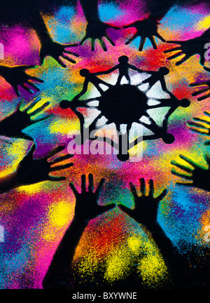 One world unity symbol surrounded by childrens hand prints made with multicoloured powder Stock Photo