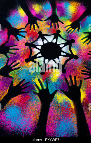 One world unity symbol surrounded by childrens hand prints made with multicoloured powder Stock Photo