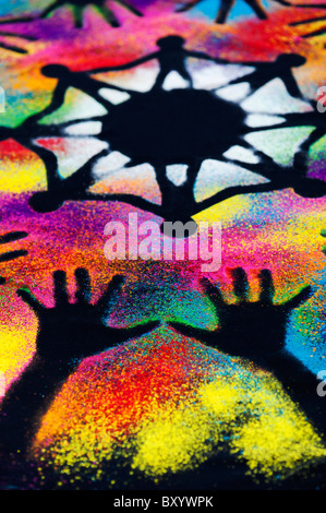 One world unity symbol surrounded by childrens hand prints made with multicoloured powder Stock Photo