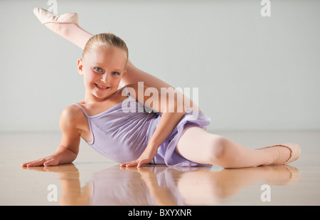 Portrait of female ballet dancer stretching in dance studio Stock Photo