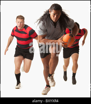 Rugby player running with ball, team chasing Stock Photo