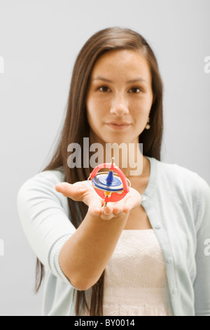 Studio portrait of young woman holding gyroscope Stock Photo