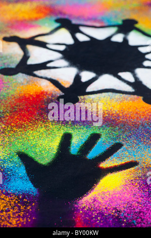 One world unity symbol surrounded by childrens hand prints made with multicoloured powder Stock Photo