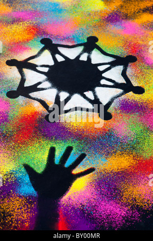 One world unity symbol surrounded by childrens hand prints made with multicoloured powder Stock Photo