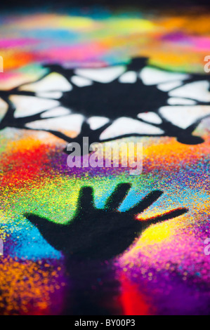 One world unity symbol surrounded by childrens hand prints made with multicoloured powder Stock Photo