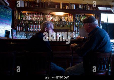 Locals drinking Guinness and beer in traditional Crotty's bar during horse fair, Kilrush, County Clare, West of Ireland Stock Photo