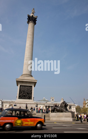 Taxi passing Nelson's Column in Trafalgar Square Stock Photo
