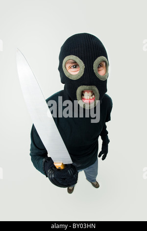 Fish-eye shot of gangster wearing black balaclava with knife in hand Stock Photo