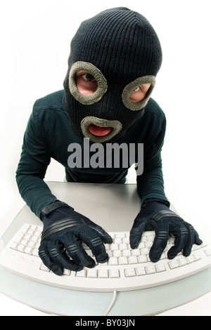 Image of criminal in balaclava pressing buttons of keyboard Stock Photo