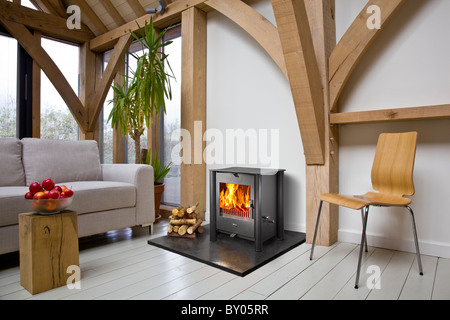 An Esse wood burning stove in an oak framed contemporary house. Stock Photo