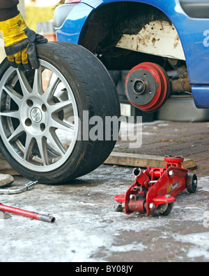 Fitter / auto mechanic applies bead sealer compound with a brush