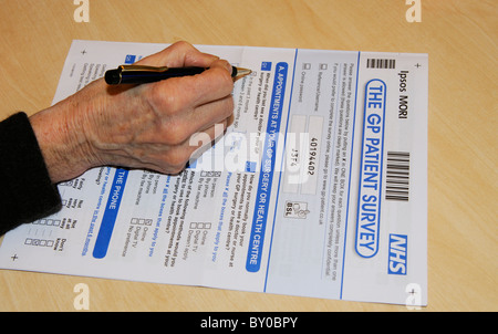 NHS GP patient survey document woman completing the questionnaire Stock Photo