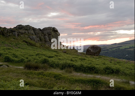 Beautiful rural scenic landscape of dramatic colourful sky at sunset over high rocky outcrop - Cow and Calf Rocks, Ilkley, West Yorkshire, England, UK