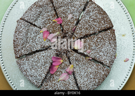 Home-baked chocolate cake with rose petals on sale at farmers' market, County Clare, West of Ireland Stock Photo
