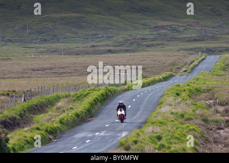 Motorcyclist on Kylemore Pass in Connemara National Park, County Galway, Ireland Stock Photo