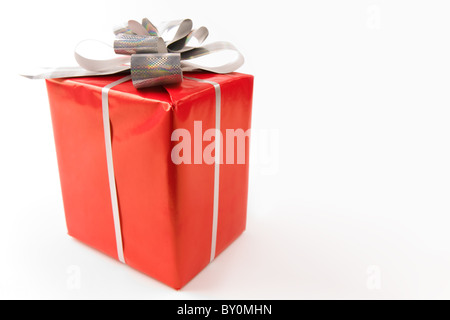 Corner of red giftbox decorated with silver shiny ribbon and knot Stock Photo