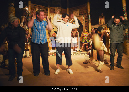 Tourists joining in with traditional Zulu dance, Shakaland, Eshowe, Zululand, KwaZulu-Natal, South Africa Stock Photo