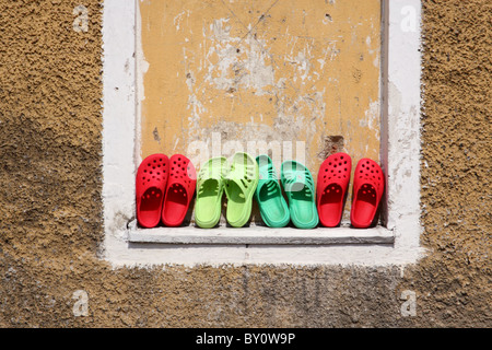 Row of clogs against the wall. Stock Photo