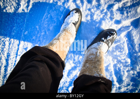 Rural valenoks in galoshes put on feet. Stock Photo